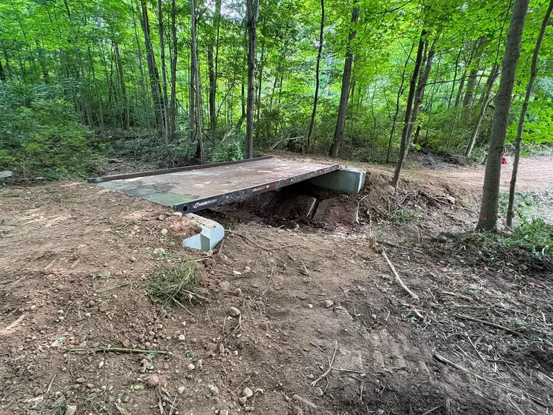 New concrete footbridge over a small creek in the woods