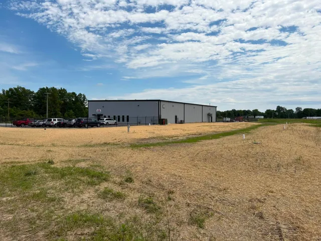 Freshly graded and strawed ground beside an industrial building