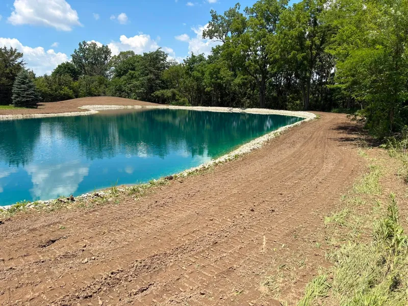 Stone shoreline and graded bank along a pond